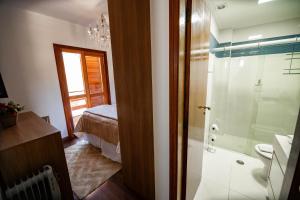 a bathroom with a shower and a bedroom with a bed at Luxuoso duplex no Capivari in Campos do Jordão