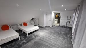 Habitación blanca con 2 camas y escalera en Comfort Sleep, en Windsor