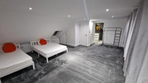 a white room with two beds and a staircase at Comfort Sleep - Rooms with shared facilities in Windsor