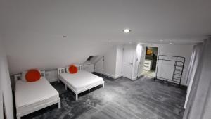a white room with two beds and a ladder at Comfort Sleep - Rooms with shared facilities in Windsor