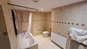 a bathroom with a tub and a sink and a toilet at Comfort Sleep - Rooms with shared facilities in Windsor