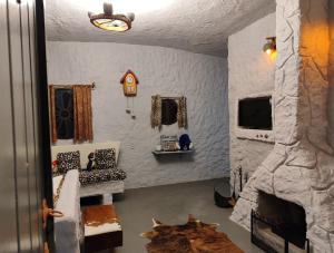 a room with a stone fireplace and a room with a door at Casa dos Flinstones, Vila Mágica in Bueno Brandão