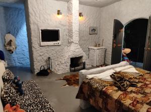 una camera da letto con camino in pietra e un letto con una sqor di Casa dos Flinstones, Vila Mágica a Bueno Brandão