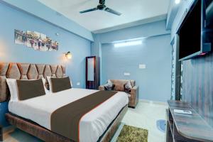 a bedroom with a bed and a flat screen tv at Collection O Hotel Dream Villa in Patna