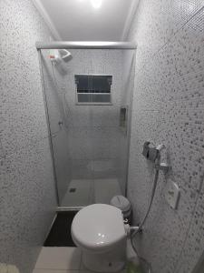 a small bathroom with a toilet and a shower at Apartamento Aconchegante in São Lourenço