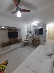 uma sala de estar com um sofá e uma ventoinha de tecto em Apartamento Aconchegante em São Lourenço
