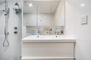 a white bathroom with a sink and a shower at Secret Garden Cottage Busselton in Busselton +28 photos