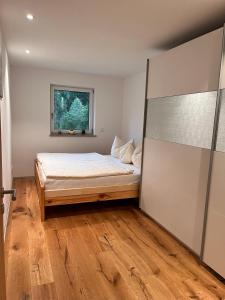 1 dormitorio con cama y ventana en Ferienwohnung Trissl, en Oberaudorf