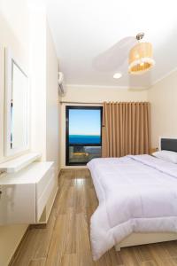 a white bedroom with a large bed and a window at Felfela View in Hurghada