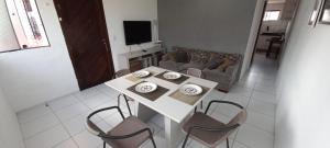 a living room with a white table and chairs at Apartamento aconchegante e bastante espaçoso in Natal