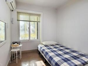 um pequeno quarto com uma cama e uma janela em Hongdae Cheese Guesthouse em Seul