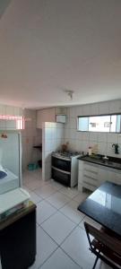 a large kitchen with a stove and a sink at Apartamento aconchegante e bastante espaçoso in Natal