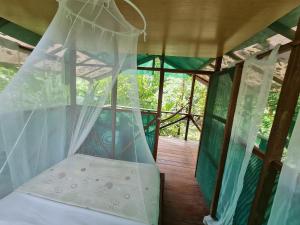 a bed in a room with a mosquito net at Rio Agujitas Eco jungle - Island and Corcovado tours in Drake
