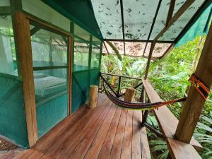 a hammock on a porch of a house at Rio Agujitas Eco jungle - Island and Corcovado tours in Drake