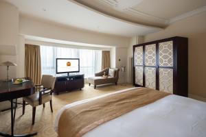 um quarto de hotel com uma cama grande e uma secretária. em Paramount Gallery Hotel em Xangai
