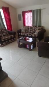 een woonkamer met banken en een salontafel bij ApartmentsWestvillage 2bedroom in Montego Bay