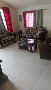 a living room with couches and a coffee table at ApartmentsWestvillage 2bedroom in Montego Bay