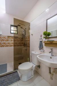 a bathroom with a toilet and a sink and a shower at Oceanside 2 bedroom house, 50Mbps WiFi in Panglao