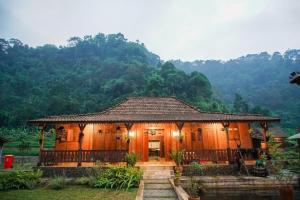 ein kleines Holzhaus mit einem Berg im Hintergrund in der Unterkunft Rumah Lembah Bogor 