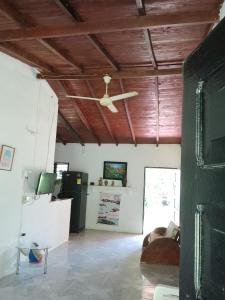 sala de estar con ventilador de techo y sofá en Mágica Cabaña familiar cerca al mar, en Coveñas