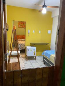 a room with two beds and a yellow wall at Namoasuites in Maceió