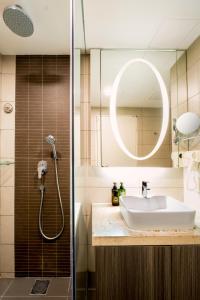 a bathroom with a sink and a shower with a mirror at Genting Ion Delemen TopSky Holiday Suite & Studio Room in Genting Highlands