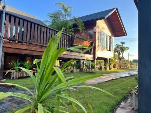 a house with a deck on the side of it at Bann Rai I Na in Phrae