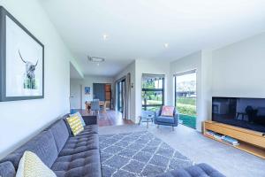 a living room with a couch and a flat screen tv at Hoheria Mountain Lodge in Wanaka