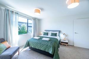 a bedroom with a bed and a large window at Hoheria Mountain Lodge in Wanaka