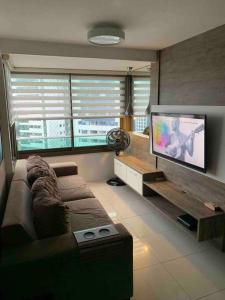 a living room with a couch and a flat screen tv at Flat 02 quartos em Boa Viagem, 2 min a pé da praia in Recife