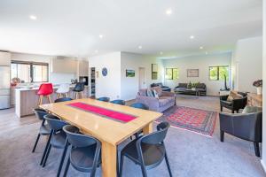 eine Küche und ein Wohnzimmer mit einem Holztisch und Stühlen in der Unterkunft Elevated Mountain Views in Wanaka + 21 Fotos