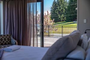 Zimmer mit einem Bett und einer Glasschiebetür in der Unterkunft Elevated Mountain Views in Wanaka