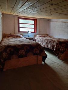 um quarto com 2 camas e uma janela em Chalé Rustic House 2 Com hidromassagem em Campos do Jordão