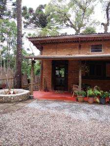 uma casa de tijolos com um pátio e uma fogueira em Chalé Rustic House 2 Com hidromassagem em Campos do Jordão