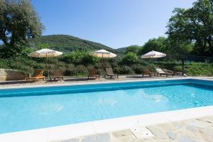 una piscina con 2 sombrillas y 2 sillas en Villa Nova by PosarelliVillas en Rosennano