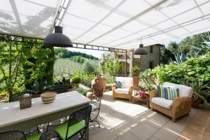 un patio al aire libre con sillas y una mesa con vistas en Villa Nova by PosarelliVillas en Rosennano