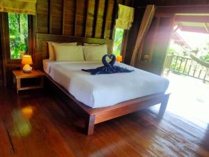 a bedroom with a bed with a swan on it at Sabai House Bungalow in Ko Yao Noi