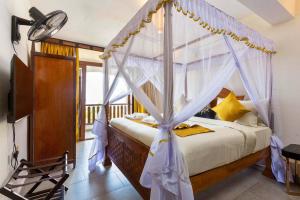 - une chambre avec un lit à baldaquin dans l'établissement Beachfront / Air-con / king bed / pool, à Ukunda