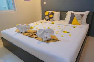 un letto con sopra dei vestiti e delle stelle di โรงแรมศุภชัย อินน์ a Ban Ba Ngan