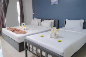 Dos camas en una habitación de hotel con flores. en โรงแรมศุภชัย อินน์ en Ban Ba Ngan