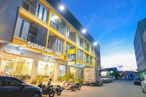 um edifício amarelo com motos estacionadas em frente em โรงแรมศุภชัย อินน์ em Ban Ba Ngan