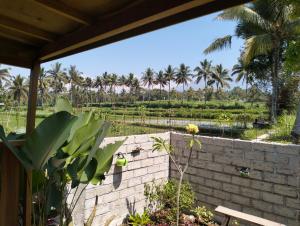 a view from the patio of a house with palm trees in the background at Sunset Point Kembang Kuning in Tetebatu