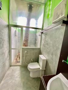 a bathroom with a toilet and a sink and a window at Green Villa in Oluvil +77 photos