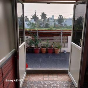 una puerta abierta a un balcón con macetas en Comfortable Room for Families & Couples! en Chamundi Extension