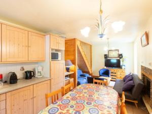 a kitchen and living room with a table and a couch at Chalet Duplex à Peyragudes – 3 Chambres, Cheminée, Terrasse, Près des Sentiers et Télécabine - FR-1-695-38 in Germ