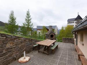 una mesa de picnic de madera sentada en una pared de piedra en Chalet Peyragudes, 4 pièces, 6 personnes - FR-1-695-38, en Germ