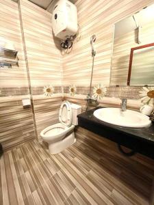 a bathroom with a toilet and a sink at New Way Hotel in Cat Ba