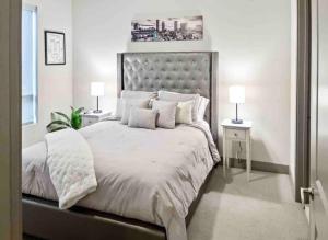 1 dormitorio con 1 cama grande con sábanas y almohadas blancas en Modern Midtown Oasis en Atlanta