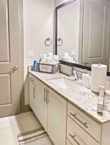 W białej łazience znajduje się umywalka i lustro. w obiekcie Modern Midtown Oasis w Atlancie
