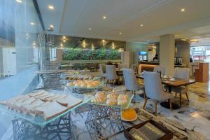 a restaurant with tables and chairs and food on display at Front One Gosyen Hotel Salatiga in Salatiga